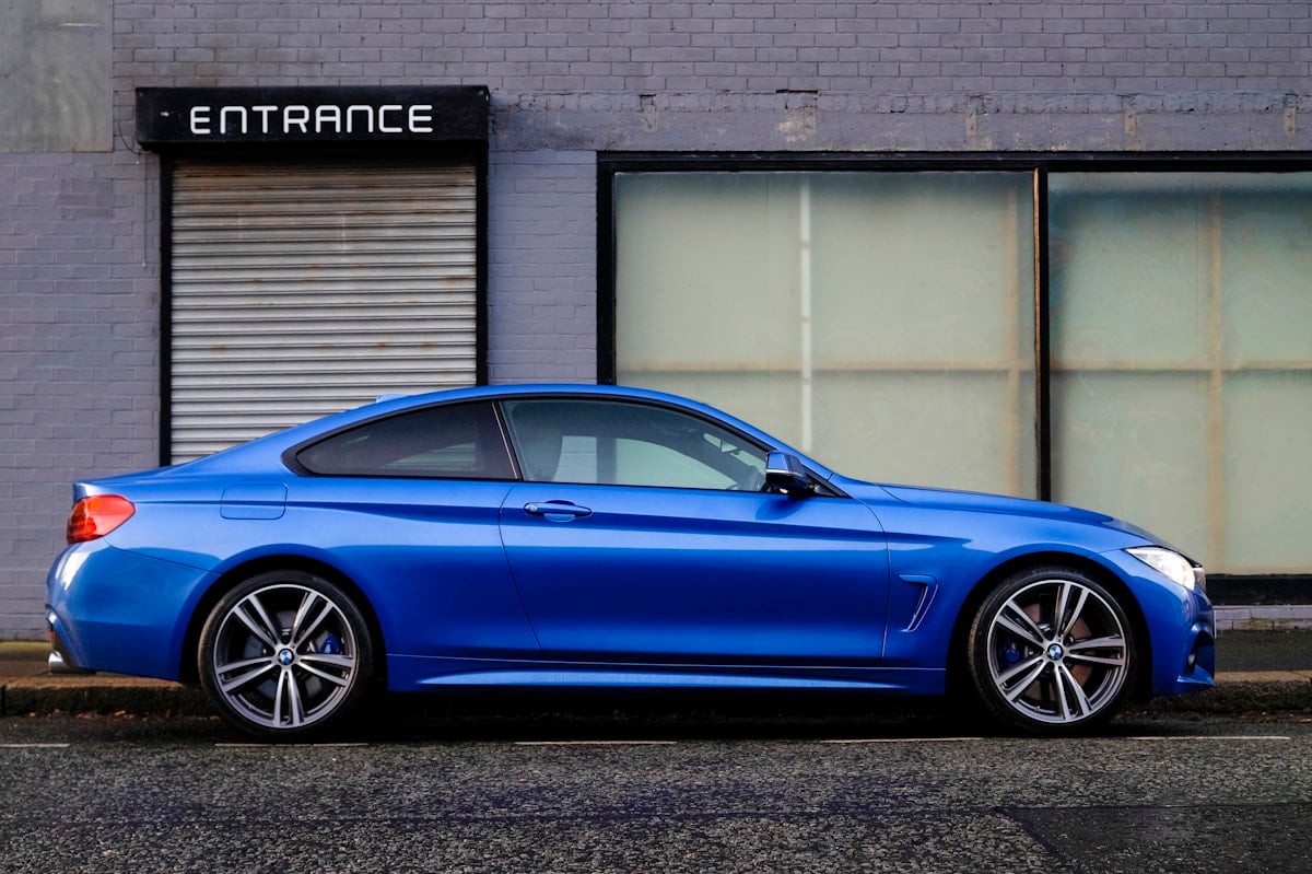 Blue car parked beside a building