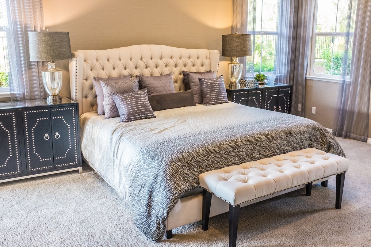 Bright bedroom with a made bed and bedside tables