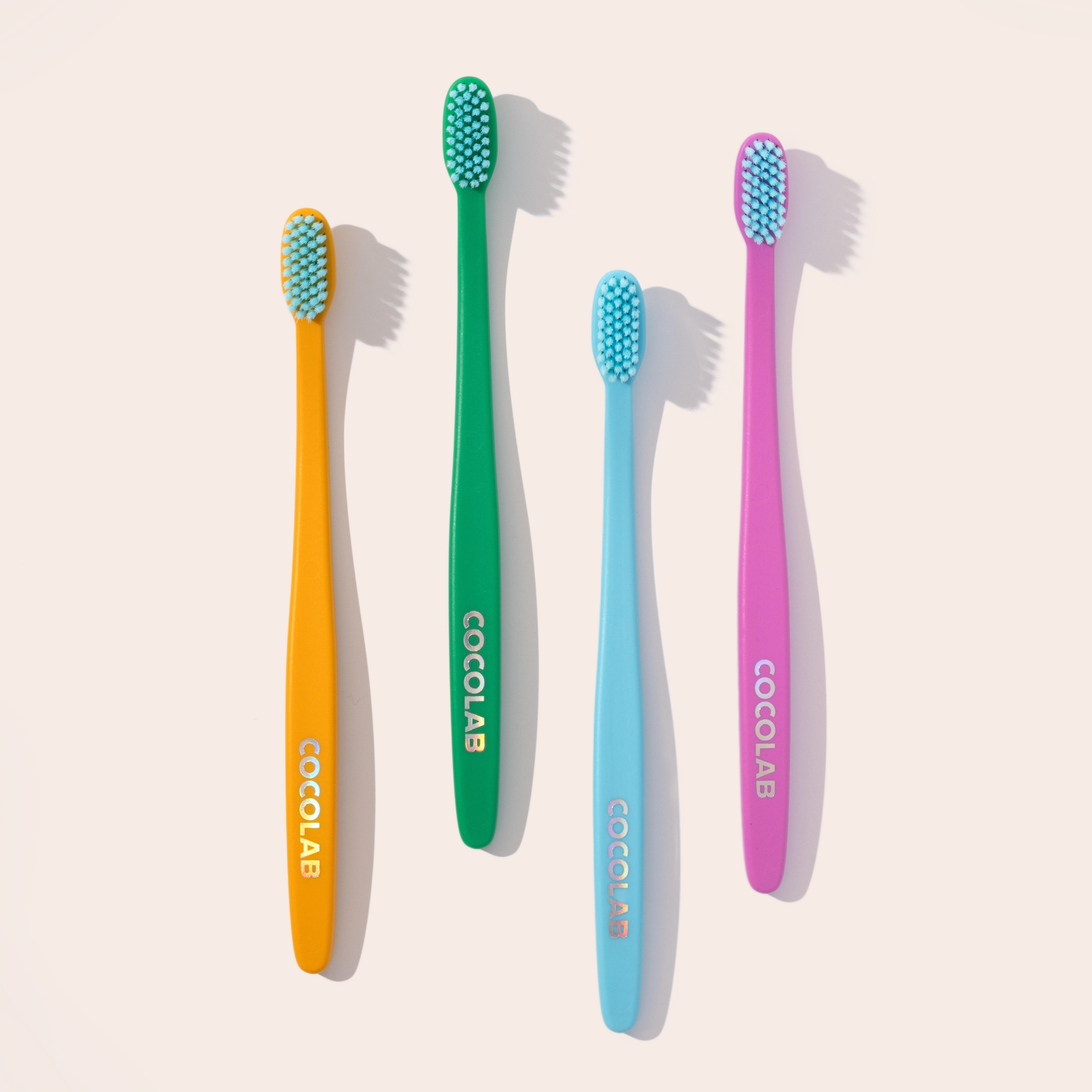 Four colorful Cocobrush toothbrushes