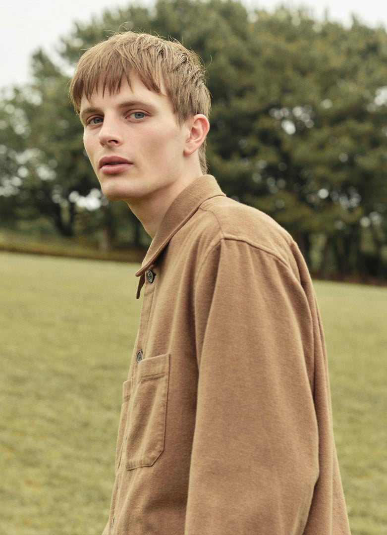 Person styling MUJI clothing in a calm autumn scene