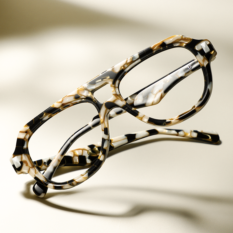 Close-up of a tortoiseshell eyeglasses frame on a light surface