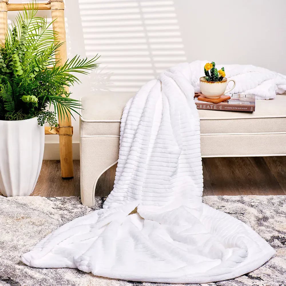 PeachyMink white throw blanket styled on a bed